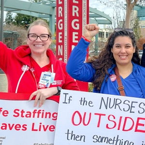 AHLM nurses picket holding signs with fists raised.