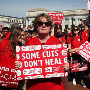 Nurses holding signs "Some Cuts Don't Heal"