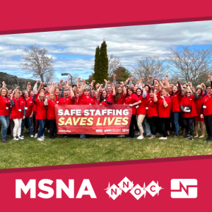 Many MSNA/NNOC nurses raise fists with banner "Safe staffing saves lives"