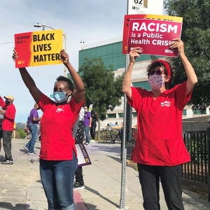 Nurses hold signs "Black Lives Matter" and "Racism is a public health crisis"