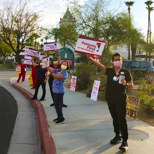 Nurses outside holding signs "Patients First in the Hospital"