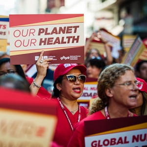 Nurse marching, one holds sign "Our Planet, Our Health"