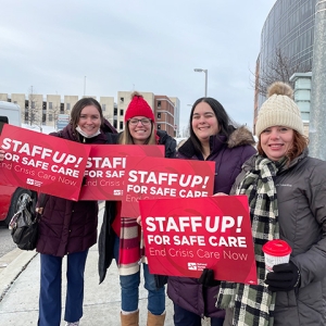 Nurses holding signs "Staff Up for Safe Patient Care"