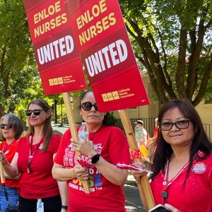 Nurses outside, holding signs "Enloe Nurses United"