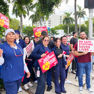 Palmetto RNs holding signs "Safe staffing saves lives" and "RN safe staffing saves lives"