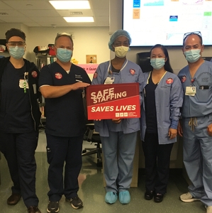 UCSF nurses hold sign "Safe Staffing Saves Lives"