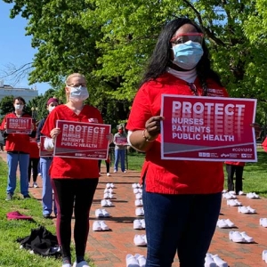 Nurses outside The White House holding signs calling for nurse, patient, and public safety