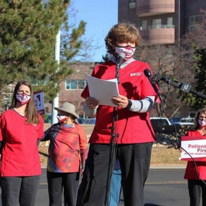 Nurses stand and speak in front of news crew