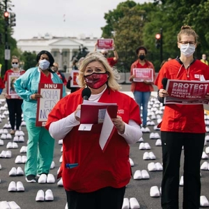 Nurses outside The White House hold signs "Protect Nurses, Patients, Public Health"