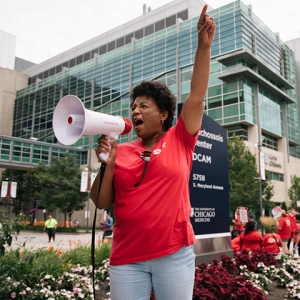 Nurse speaking through bullhorn with arm raised