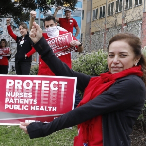 Nurses outside facility holding action