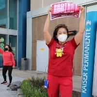 Nurses outside facility holding action