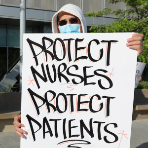 Nurse holds "Protect Nurses" signs