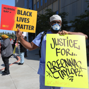 Nurse holds sign "Breonna Taylor"