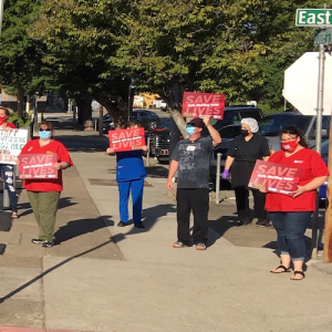 Medical workers hold signs "Safe Staffing Now"