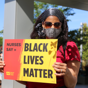 Nurse holds sign "Nurses say Black Lives Matter"