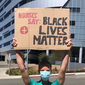 Nurse holds sign "Nurses say Black Lives Matter"