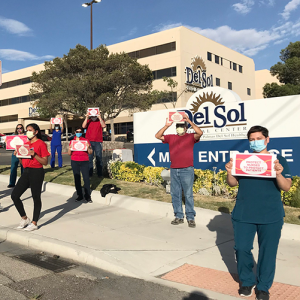 Nures hold signs calling for safety measures outside Del Sol Medical Center
