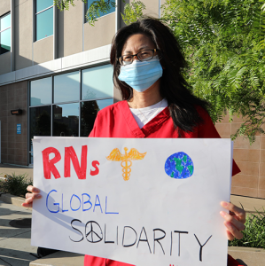 Nurse holds signs "RNs Global Solidarity"