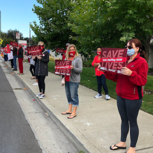 Nurses hold sign "Save Lives, Safe Staffing"