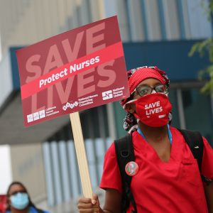 Nurse holds "Protect Nurses" sign