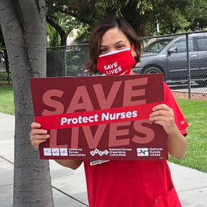 Nurse holds sing "Save Lives"