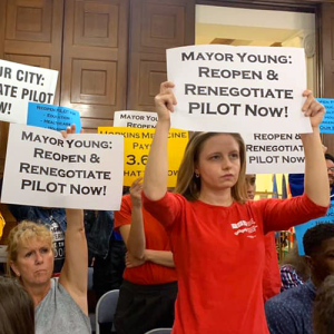 People holding signs calling for pilot renogotiation