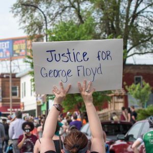 Crowd with person holding sign "Justice for George Floyd"