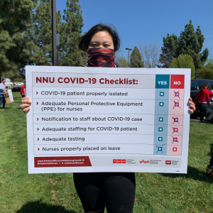 LA nurse holds sign "NNU Covid-19 Checklist"