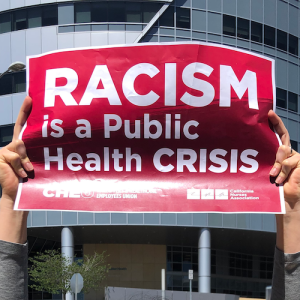 Nurses hold signs "Racism is a Public Health Crisis"