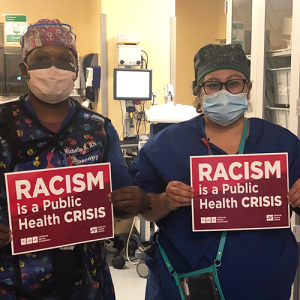 Nurses hold signs "Racism is a Public Health Crisis"