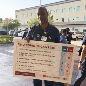 Nurse holds sign "NNU Covid-19 Checklist"