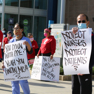 Nurses hold "Protect Nurses" signs