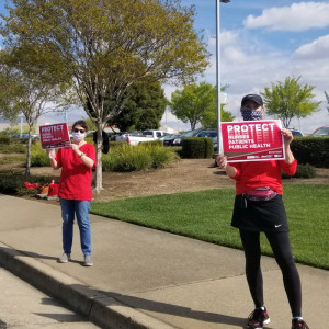 Nurses hold "Protect Nurses" signs 