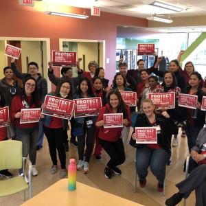 Nurses hold "Protect Nurses" signs