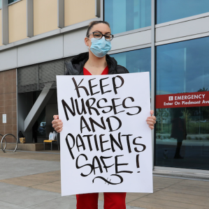 Nurses hold sign "Safe Nurses, Safe Patients"