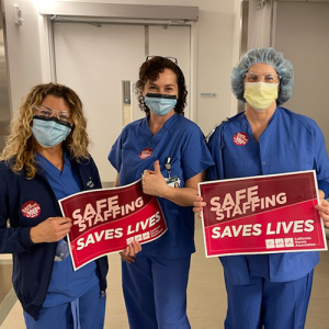 Nurses hold signs calling for safe staffing