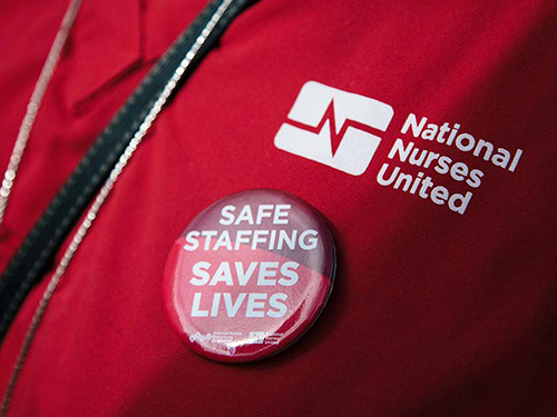 Close up of nurse scrub with pin "Safe Staffing Saves Lives"