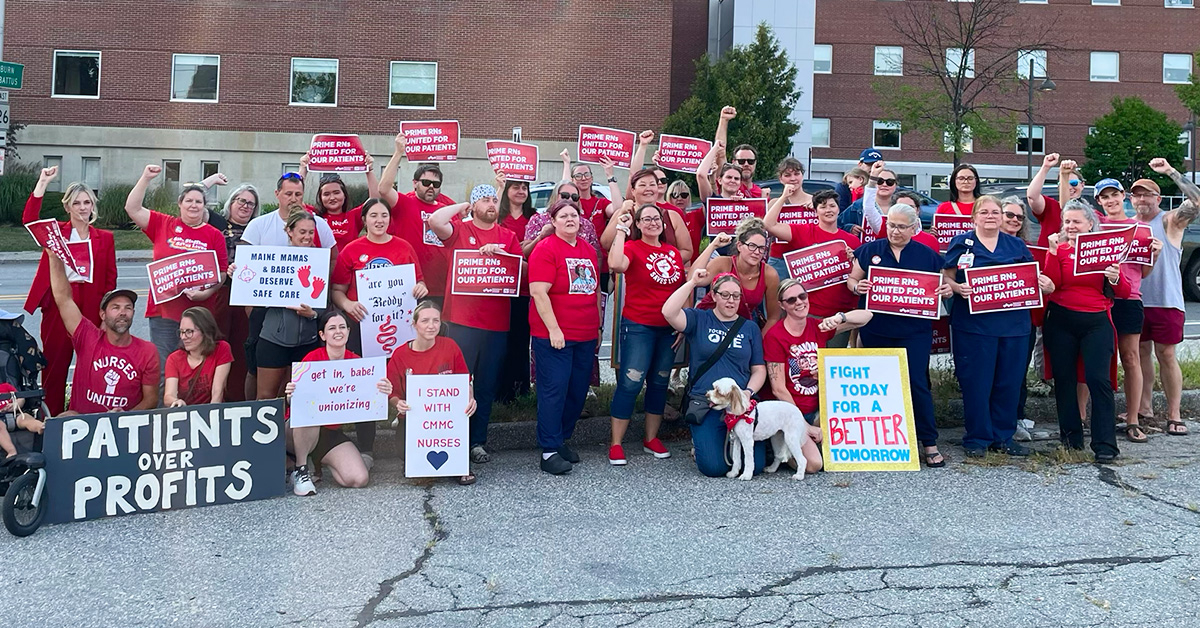 Large group of nurses outside hospital holding signs "Prime RNs United for our Patients"