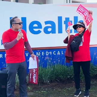 Nurses speaking out in front of UCI Health Fountain Valley sign