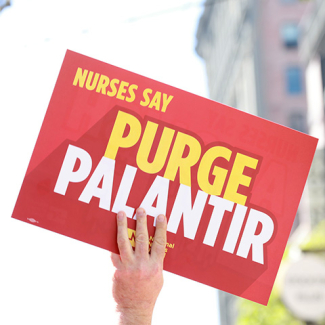 Hand holding sign '"Nurses Say Purge Palantir"