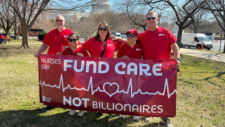 Five nurses holding banner "Fund Care NOT Billionaires"