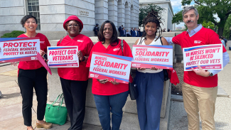Five nurses holding signs "Protect Federal Workers, Protect VA nurses"