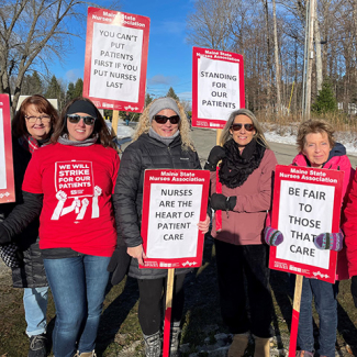 Group of nurses on picket line holding signs