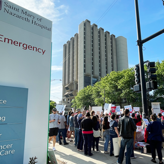 Nurses on sidewalks in front of Saint Mary of Nazareth Hospital emergency