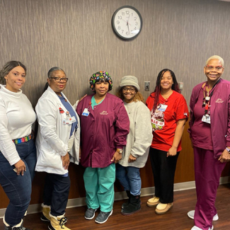 Group of six nurses, side-by-side, smiling