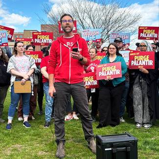 Maine nurses holding signs "Nurses say Purge Palantir" and "Nurses say Abolish ICE"
