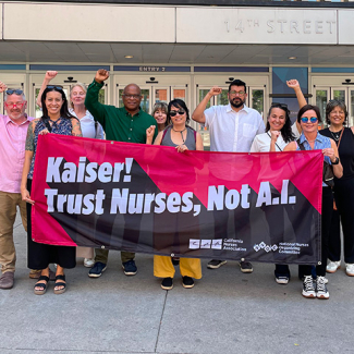 Group of nurses outside, with raised fists, holding banner "Kaiser! Trust Nurses, Not A.I."