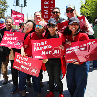 Group of nurses holding signs "Trust Nurses Not A.I." and "Patients are NOT algorithms"