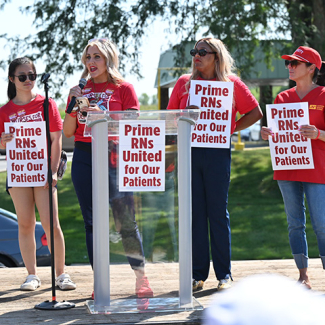 4 nurses at podium holding signs "Prime RNs United for our Patients"